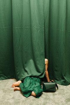 Person Hiding Behind Green Curtain with Handbag
