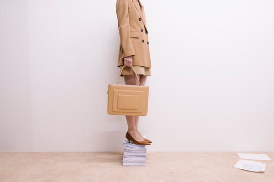 Businesswoman Standing on Files with Briefcase