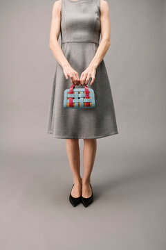 Woman Holding Colorful Handbag Wearing Gray Dress