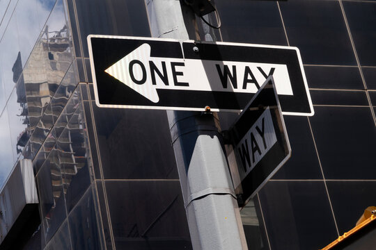 Traffic signs for one way street on black background