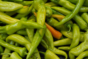 a pile of fresh green chili peppers in the store