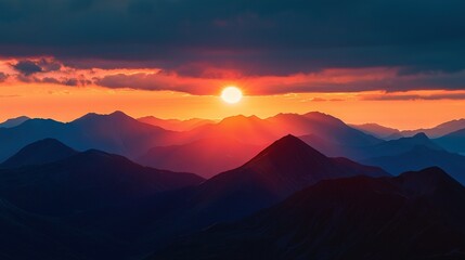 Fototapeta premium Sunset on mountain range with foreground mountains & cloudy background