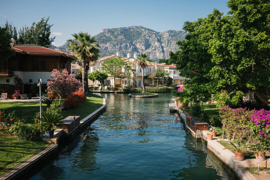 Picturesque Canal with Waterfront Houses and Mountains