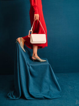 Elegant Woman in Red Dress with White Handbag and Heels