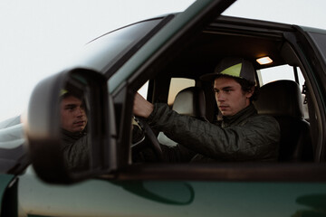 Man drives his car in evening sunset light.