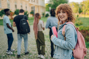 Fototapeta premium Close up of ginger female university student at campus smiling at camera