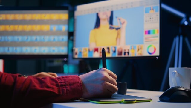 Photo editor editing images, doing color correction in post production company using graphic tablet. Photographer fixing overexposed pictures with stylus on touchscreen device, close up shot