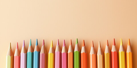 colored pencils and various stationery items, like small notebooks, against an isolated pastel cream background