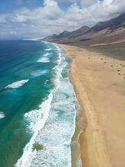 Słynna, piękna, naturalna plaża Fuerteventury Playa de Cofete położona wśród gór. The famous, beautiful, natural beach of Fuerteventura, Playa de Cofete, located among the mountains.