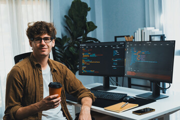 IT developer in online software development looking at camera and holding coffee cup surrounded...