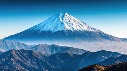 Close-up of Mount Fuji snowy peak against a clear blue sky, highlighting the mountain majestic and imposing presence