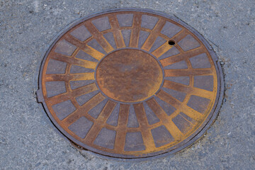 Rusty cast iron manhole cover close-up.