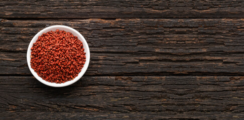 Red organic annatto seeds in the bowl - Bixa Orellana