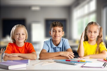 Fototapeta premium Portrait of positive school children sitting in classroom