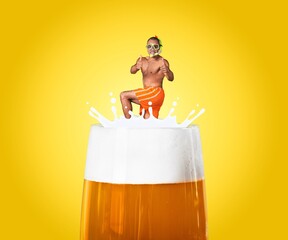Man in swimsuit floating at top of foamy beer glass