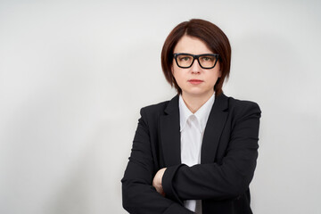 Portrait of businesswoman wearing black suit and glasses on grey background