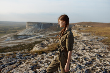 Woman standing on cliff edge admiring beautiful landscape in travel adventure concept