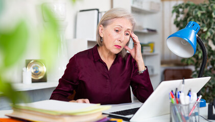 Upset woman with documents in company at a modern workplace