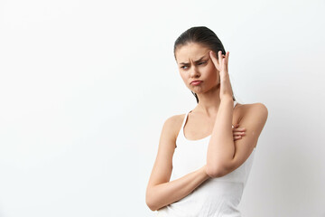 Concerned young woman with hand on head, frowning expression against a minimalistic white background, conveying feelings of confusion or worry in a clean design