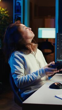 Vertical video Freelancing programmer listening music while designing and developing software applications. IT specialist wearing headphones, implementing and maintaining company systems, camera B