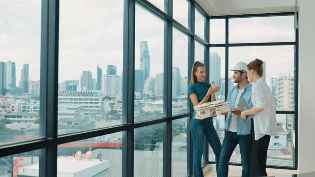 Project manager holds house model while architect engineer team share, brainstorm, discuss about house design or building construction. Interior designer standing near window with city. Tracery