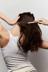 Fototapeta premium Hair care routine, woman grooming, healthy hair concept, combing hair, natural beauty, hairstyle tips, self care, portrait of woman with long hair, minimalist background