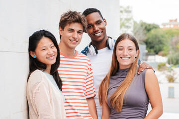A diverse group of friends smiles joyfully outdoors, celebrating their bond while engaging in...
