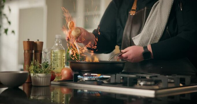 Food, fire and frying pan with hands of person in kitchen for cooking, flame and meal prep. Nutrition, cuisine and dinner with chef and flambe at home for wellness, dining and healthy ingredients