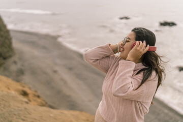 Tourist listening music with headphones on the beach