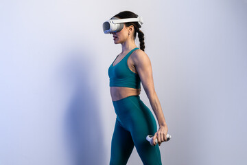 Woman exercising with virtual reality headset and dumbbells