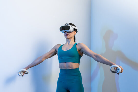 Woman experiencing VR fitness with VR headset and controllers