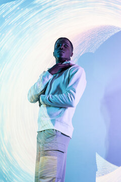 Person in white hoodie illuminated by artistic light trails