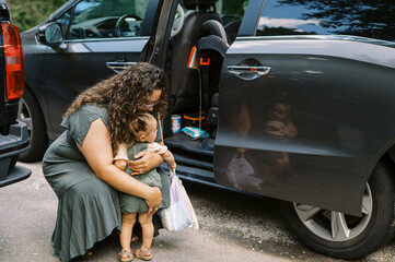 mother and daughter by minivan in driveway