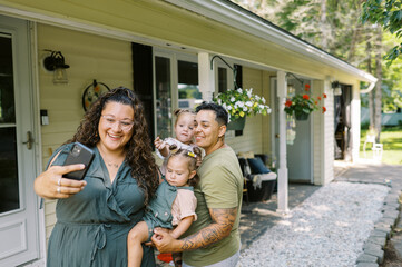 smiling lgbtq family taking selfie with key and new house