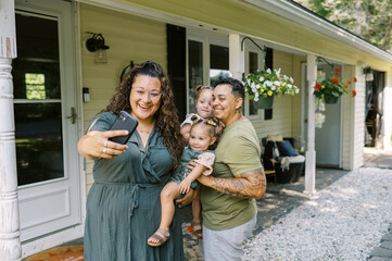 smiling lgbtq family taking selfie with key and new house