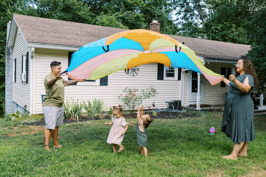 playful happy lgbtq family with mothers and toddler daughters