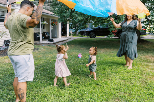 playful happy lgbtq family with mothers and toddler daughters