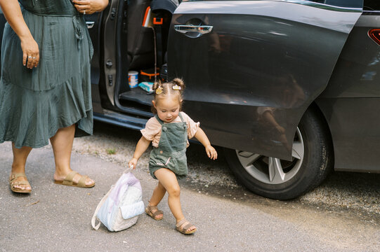 mother and daughter by minivan in driveway