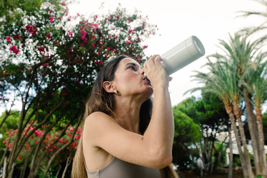 An athlete drinking water from a jerry can to recover energy