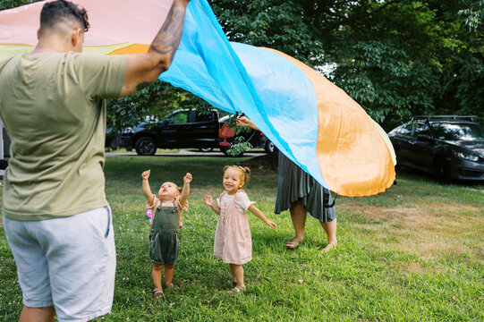 playful happy lgbtq family with mothers and toddler daughters