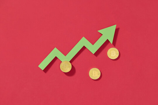 Green arrow pointing upwards with bitcoin coins on a red background,