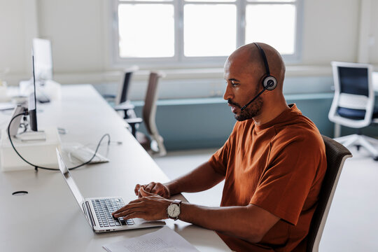 Customer service representative working on laptop in office