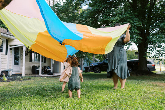 playful happy lgbtq family with mothers and toddler daughters
