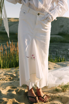 CloseUp of Woman in White Skirt with Embroidered Flowers