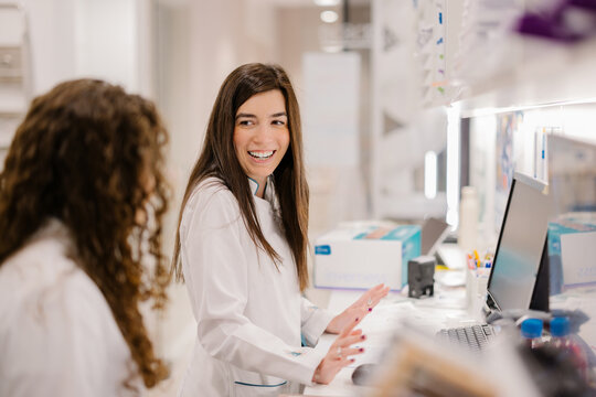 Drugstore professionals working with joy in a modern pharmacy