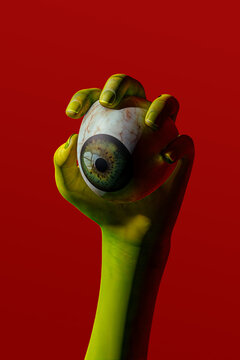 Green hand holding eyeball. Halloween concept