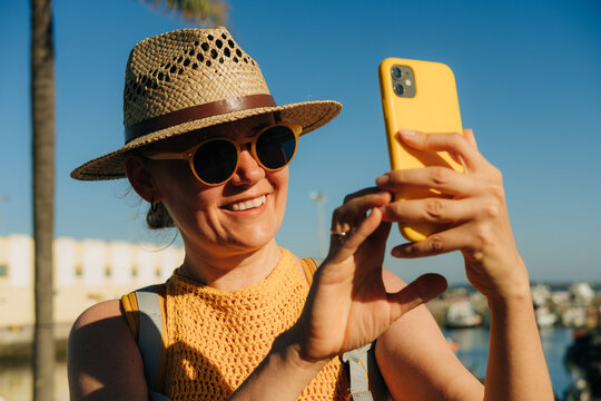 Positive portrait of a female tourist smiling while making selfi