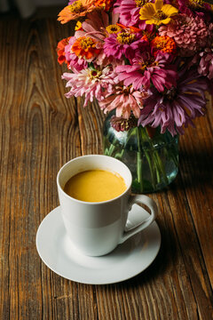 Turmeric Latte and Flowers on Table