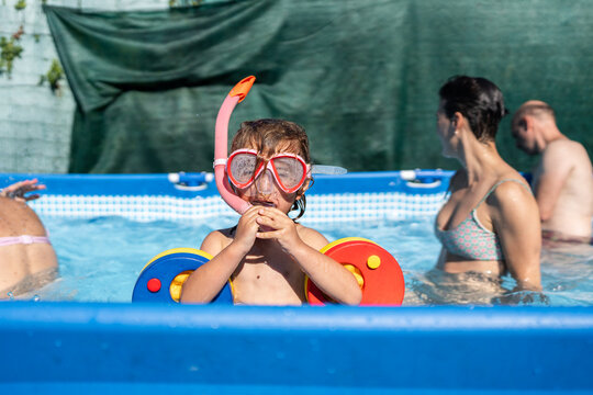 Little boy with diving mask and armbands playing in a swimming