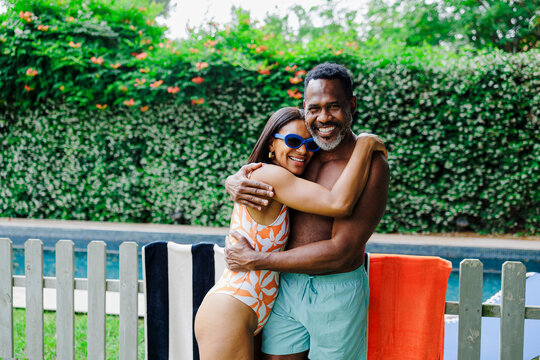 Happy couple embracing by the swimming pool